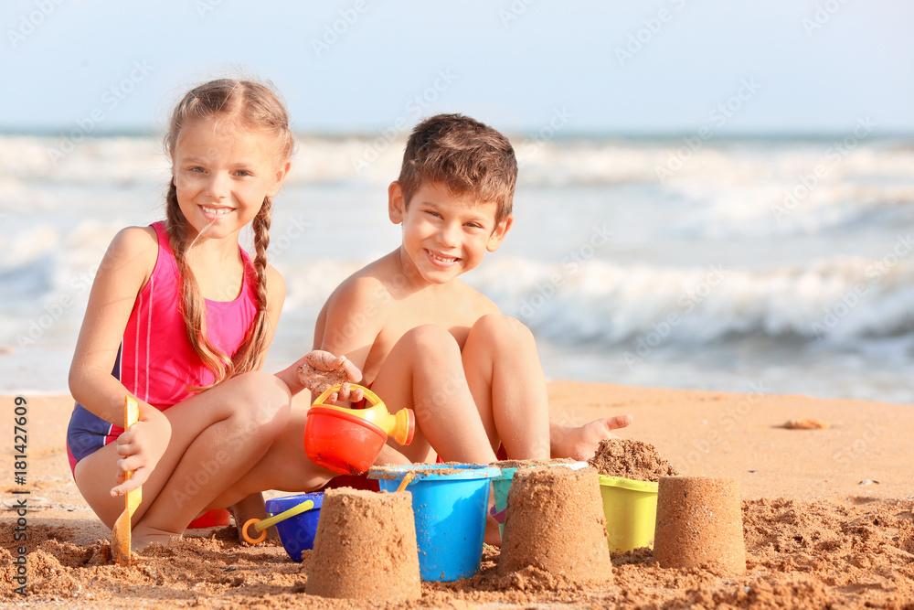 Canvas Prints cute children playing with sand on sea beach