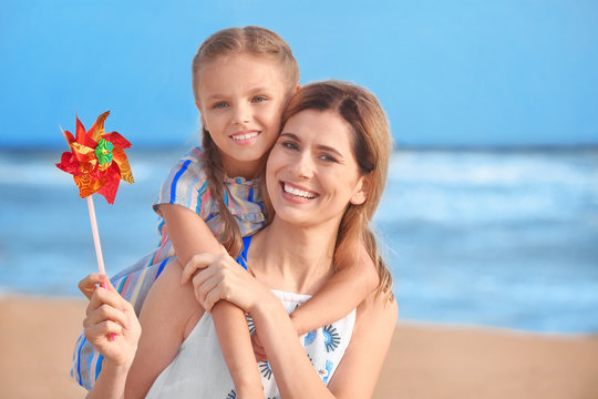 Cute little girl with mother on sea beach at resort