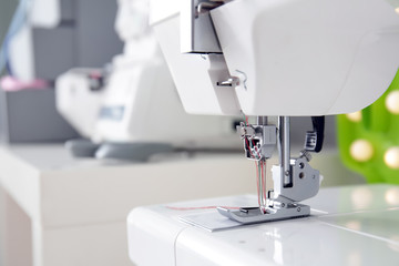 Sewing machine on table in tailor's workshop, closeup
