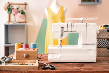 Fototapeta na wymiar Sewing machine on table in tailor's workshop