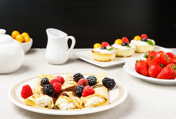 Crepes stuffed with cheese and berry topping on a plate for breakfast.