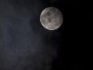 Fototapeta na wymiar A full moon under heavy cloud in the night sky, Thailand