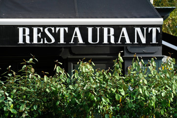 Fototapeta na wymiar Canopy of restaurant sign with bush