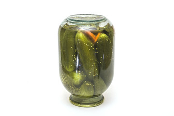 Pickled cucumbers isolated. Pickles in glass jar with garlic and peppercorn isolated on white background.