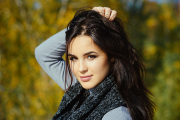 Fototapeta premium Woman touch long brunette hair on sunny day