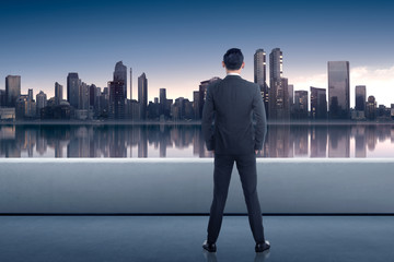 Back view of asian businessman looking at cityscape