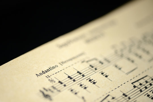 Musical tempo "Andantino" in an old music notebook close up