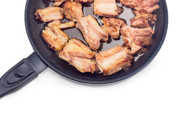 Fragment of frying pan with fried pork ribs