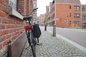 Streets of Antwerp. A bicycle with a child seat is located near the wall in the picturesque and authentic street of Antwerp. Culture of Belgium.

