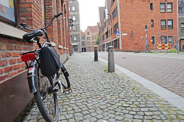 Streets of Antwerp. A bicycle with a child seat is located near the wall in the picturesque and authentic street of Antwerp. Culture of Belgium.

