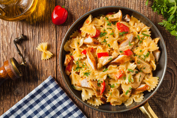 Pasta farfalle with chicken and paprika, in carbonara sauce.