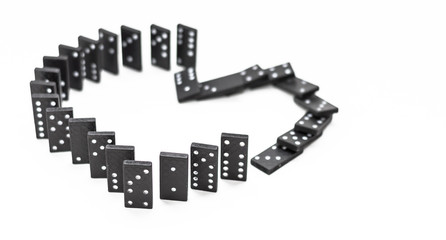 separation or breaking up the love (black dominoes in the form of hearts fall in a Domino effect on white background)