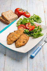 breaded fish fillet with salad
