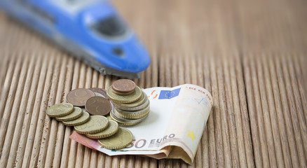 Euro banknote and coins on brown wooden plank. , use as Business and finance concept or Investing in Mass Transit.