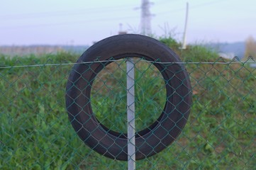 Tire on the wire mesh fence (Pesaro, Italy)