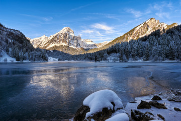 Gefrorener See, Spiegelung der schneebedeckten Berge, blauer Himmel mit Wolken, Obersee, Br&uuml;nnelistock, Glarus, Schweiz 