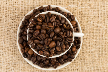 Top view of ceramic cup of coffee with roasted beans