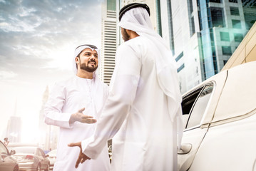 Two arabian businessmen talking about business in the company limousine