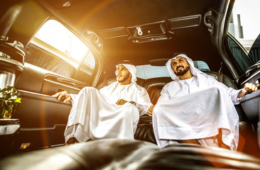 Obraz premium Two arabian businessmen talking about business in the company limousine