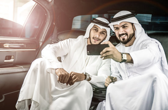 Two arabian men taking selfie inside their limousine