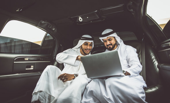 Two arabian businessmen talking about business in the company limousine