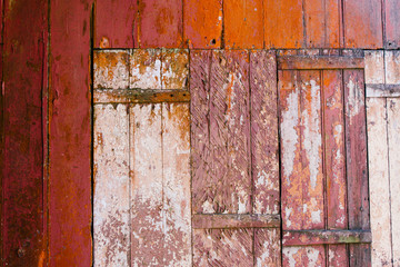 Old grunge and weathered red and white wooden wall planks texture background marked by long exposure to the elements outdoors.