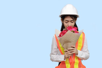 Attractive young Asian woman engineer holding a bouquet of red roses on blue isolated background.