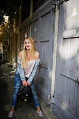 Blonde girl wear on jeans jacket posed at street.