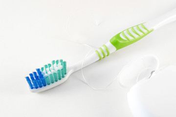 Toothbrush and dental floss on white background