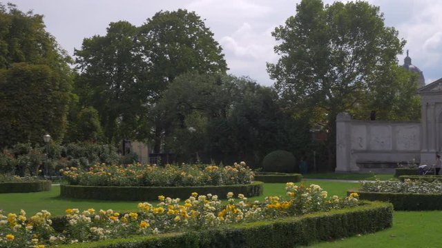 Pan across Volksgarten with blooming yellow roses in front in Vienna, Austria. Taken sunny morning
