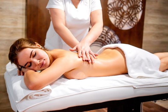 Masseur woman doing relaxing massage young girl at Spa salon