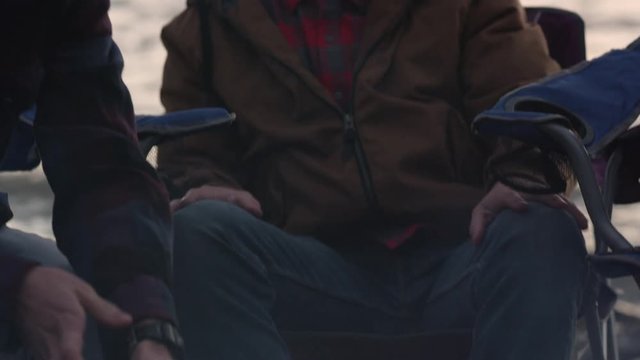 Panning Down From Two Brothers Faces To Campfire They Are Sitting Around On Cold Evening.