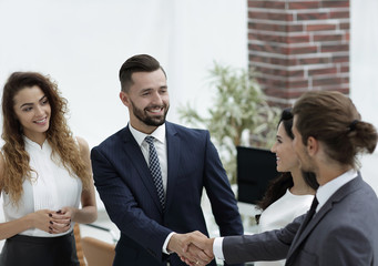 handshake business partners in the office.