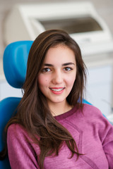 Beautiful girl with dental braces smiles in dentistry.
