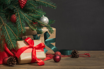 Christmas holiday background. Gifts with a red ribbon, Santa's hat and decor under a Christmas tree...