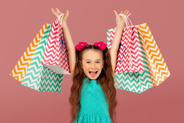Sale. Cute little girl with many shopping bags. Portrait of a kid on shopping.