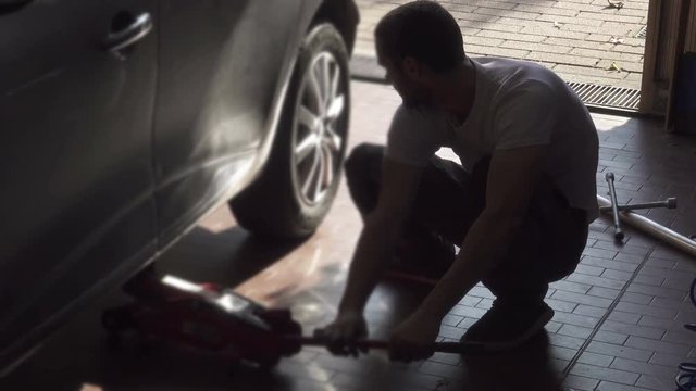 Young Mechanic Changing Car Tire, Fixing Wheel