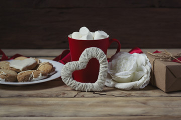 Valentine's day concept. Gift, marshmallow in a red cup, cookies in the form of a heart, rose and heart handmade