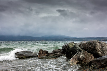 Large blocks of stones on the shore of the lake on a cloudy day