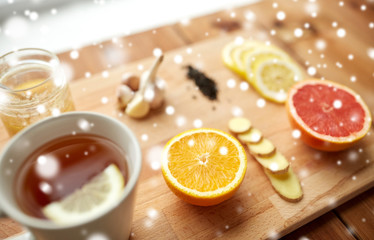 ginger tea with honey, citrus and garlic on wood