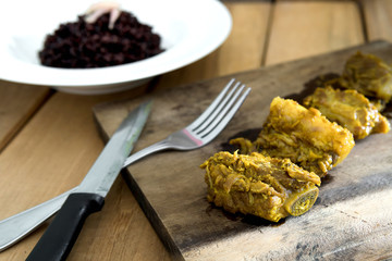 Curry pork ribs on a chopping board Riceberry Rice was placed on the back, ready to eat. Food is spicy in the form of Thailand.