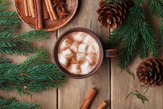 Cup of hot cocoa with marshmallows on rustic wooden table top view. Cozy winter still life.
