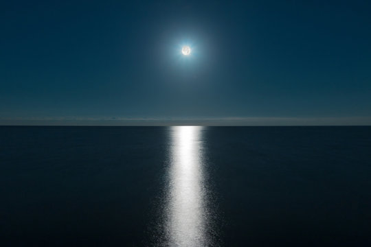 Seascape with the full moon over the sea and the moon glade
