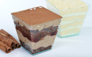 Layered delicious chocolate dessert with cream cheese in a glass on light background, selective focus