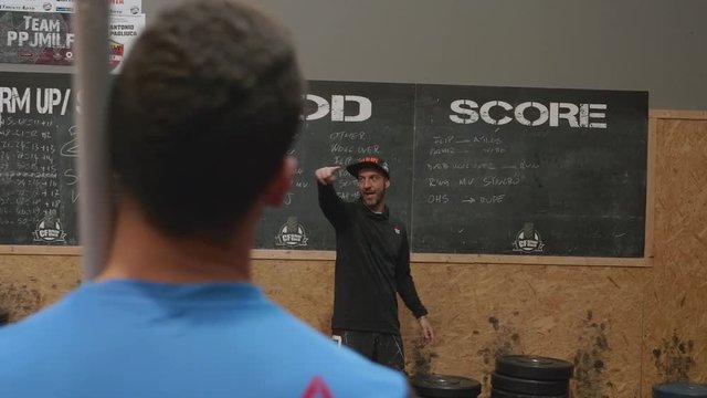 Coach explaining exercise plan in a Crossfit gym