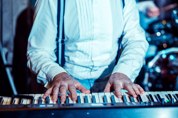 Musician 45-50 years of European appearance. Hands of a man who plays a synthesizer.