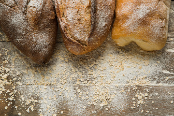Variations of bread on the top of wooden table with flour