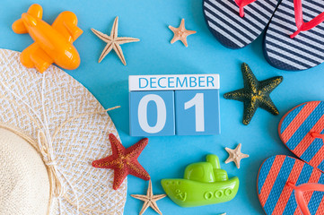 December 1st. Image of december 1 calendar with summer beach accessories and traveler outfit on background. Winter like Summer vacation concept