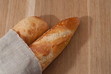 Two baguettes wrapped in a linen napkin