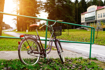 Fototapeta na wymiar Bicycle with basket parked near urban railings, outdoors